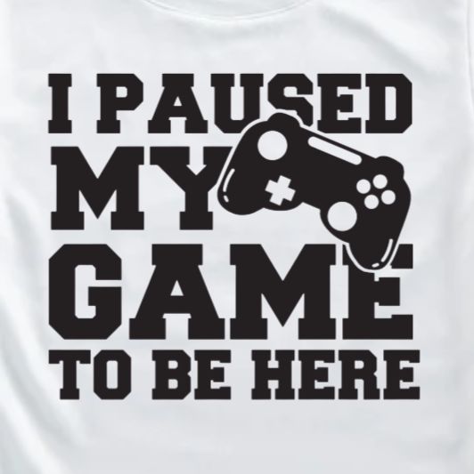 White t-shirt with black text and game controller graphic on a white background